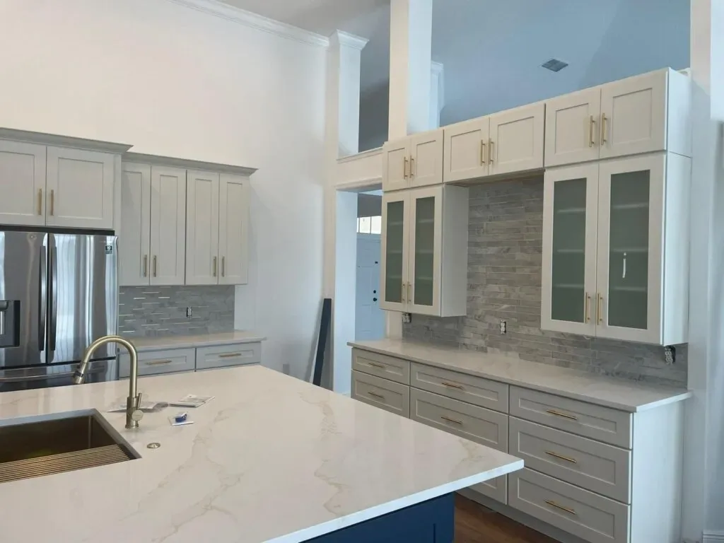 Orlando kitchen renovation with a broad island, white cabinetry, and gray tile